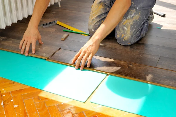 Carpintero haciendo trabajo de piso laminado —  Fotos de Stock