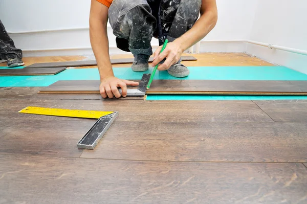 Carpinteiro fazendo piso laminado — Fotografia de Stock