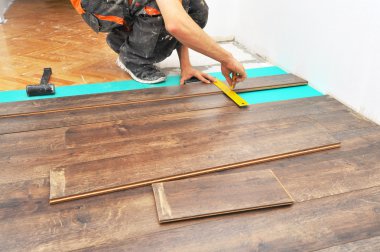 Carpenter doing laminate floor work clipart
