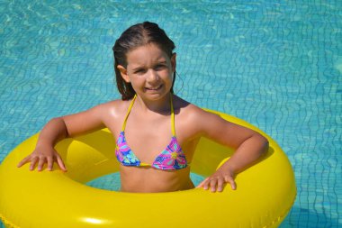 Çok tatlı bir kız, yüzme havuzunda dinleniyor, yaz tatili konsepti.