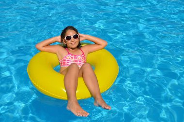 Çok tatlı bir kız, yüzme havuzunda dinleniyor, yaz tatili konsepti.