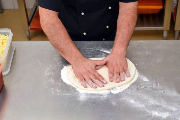 피자를 만드는 요리사 요리사 주방에서 피자를 만들고 있습니다 스톡 사진