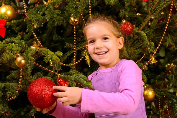 Adorável menina criança segurando decorativo bola de brinquedo de Natal — Fotografia de Stock