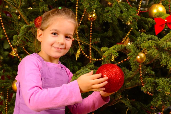 Adorável menina criança segurando decorativo bola de brinquedo de Natal — Fotografia de Stock