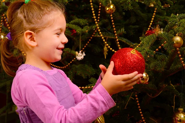 クリスマス グッズのくす玉を保持している愛らしい幼児の女の子 — ストック写真