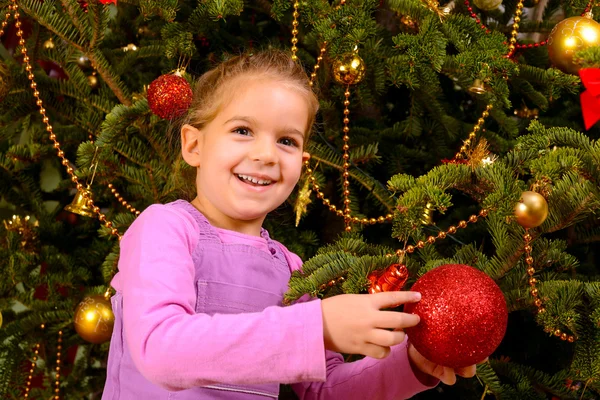 クリスマス グッズのくす玉を保持している愛らしい幼児の女の子 — ストック写真