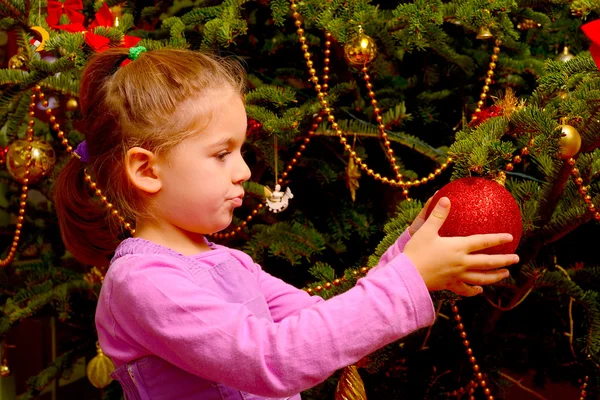 Adorável menina criança segurando decorativo bola de brinquedo de Natal — Fotografia de Stock