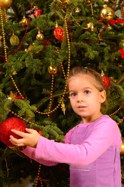 Toddler biały dziewczynka gospodarstwa dekoracyjne świąteczne zabawki piłki — Zdjęcie stockowe