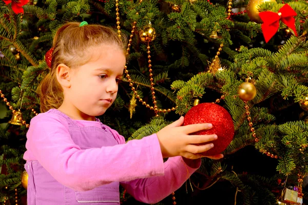 Roztomilé batole dívka drží dekorativní vánoční hračka míč — Stock fotografie