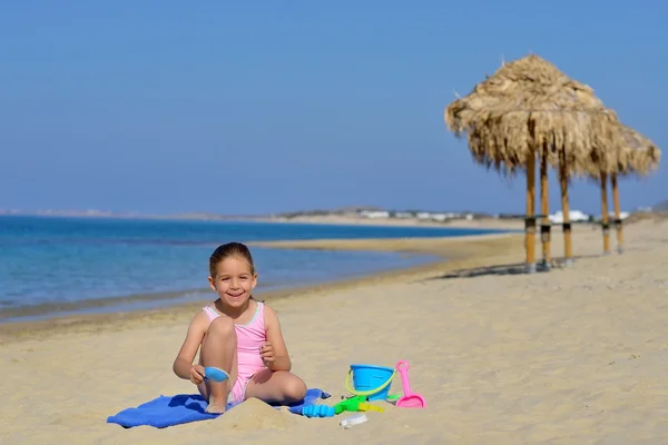 Çok güzel bebek kız sahilde ona oyuncaklar ile oynama — Stok fotoğraf