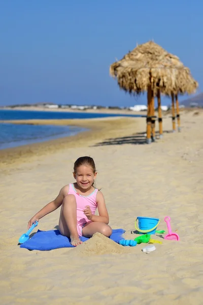Çok güzel bebek kız sahilde ona oyuncaklar ile oynama — Stok fotoğraf