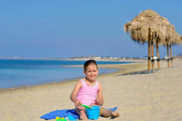 Adorable niña jugando con sus juguetes en la playa —  Fotos de Stock