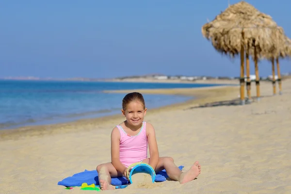 Adorable toddler girl playing with her toys at the beach — Stock Photo, Image