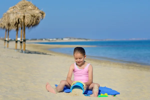 Roztomilé batole dívka si hraje s její hračky na pláži — Stock fotografie