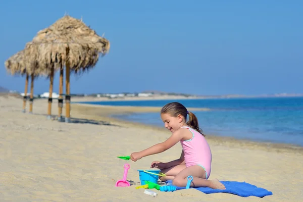 Çok güzel bebek kız sahilde ona oyuncaklar ile oynama — Stok fotoğraf