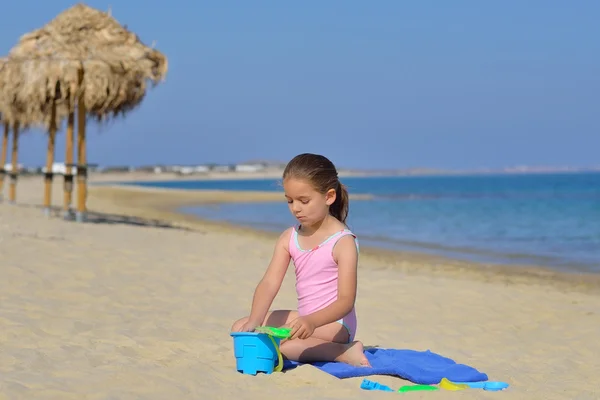 Çok güzel bebek kız sahilde ona oyuncaklar ile oynama — Stok fotoğraf