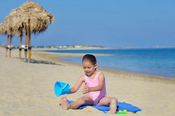 Çok güzel bebek kız sahilde ona oyuncaklar ile oynama — Stok fotoğraf