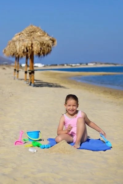 Çok güzel bebek kız sahilde ona oyuncaklar ile oynama — Stok fotoğraf