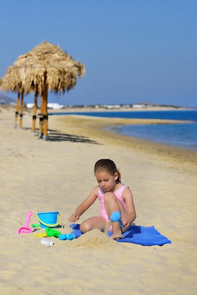 Roztomilé batole dívka si hraje s její hračky na pláži — Stock fotografie