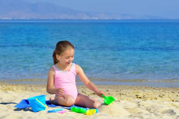 Adorable toddler girl playing with her toys at the beach — Stock Photo, Image