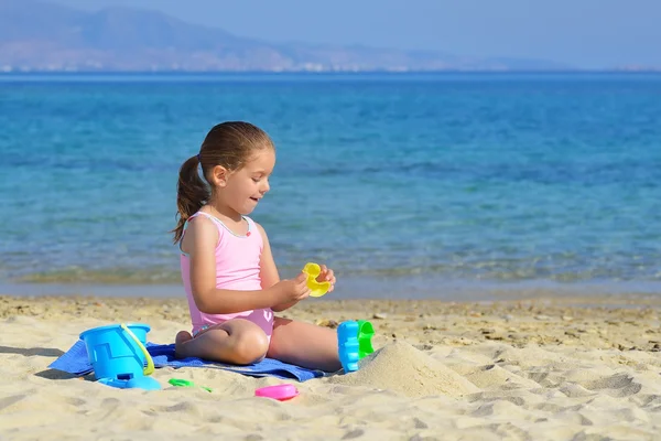 可爱的蹒跚学步的女孩，在沙滩上玩她的玩具 — 图库照片