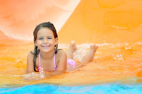 Menina adorável criança na corrediça de água em aquapark — Fotografia de Stock