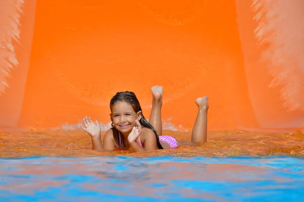 Adorable toddler girl on water slide at aquapark — Stock Photo, Image