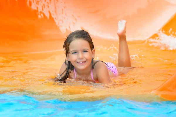 Очаровательная девочка на водной горке в аквапарке — стоковое фото