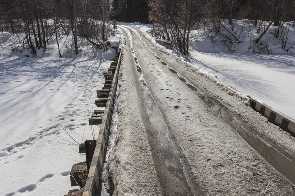 Old road bridge over a frozen river in winter