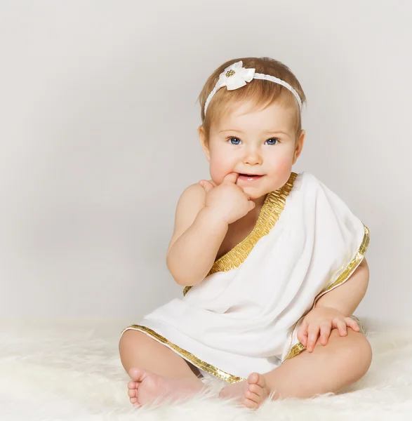 Baby flicka Finger i munnen, småbarn Kid i vitt sitter, grå — Stockfoto