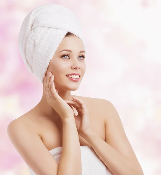 Femme enveloppée dans une serviette de bain, toucher la peau du visage, spa de beauté — Photo