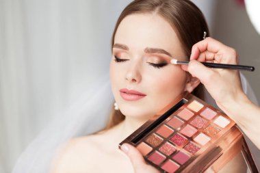 Profesyonel Gelin Makyajı yapan bir düğün sanatçısı. Gelin Gözhadow Palette. Düğün Kozmetik Salonu Yüzü. Güzellik Gelini Yüzü Kapalı Gözler