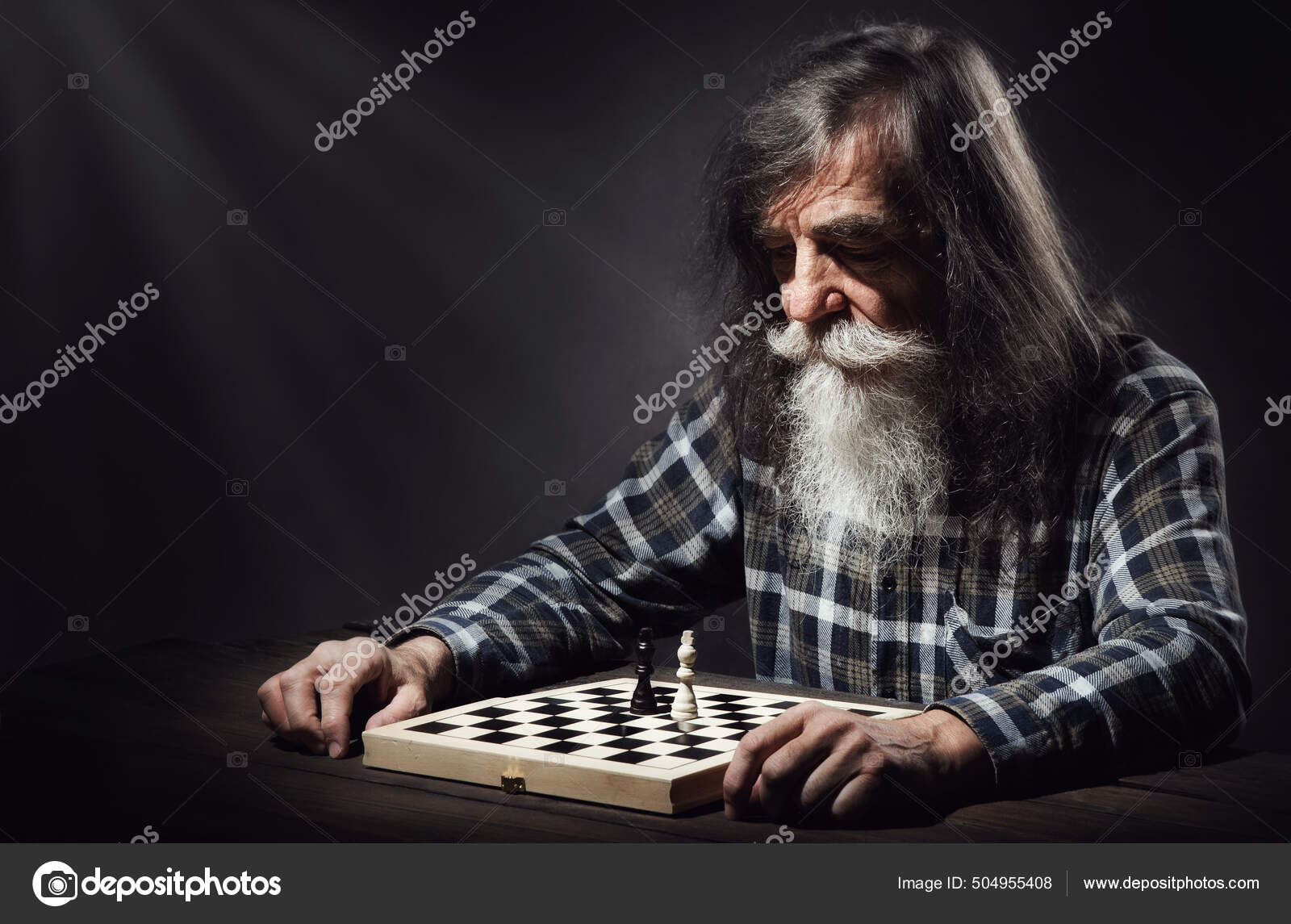 Young pensive man sitting and playing chess online