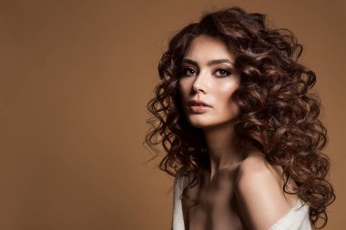 Kıvırcık saçlı kadın. Koyu Kahverengi Arkaplanda Güzellik Saçlı Kız. Smokey Eyes ile Esmer Model Kamera bakarak makyaj