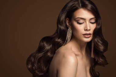 Uzun Parlak Dalgalı Saç Tarzı Esmer Modeli. Lüks Saç Bakımı. Kahverengi Stüdyo Arkaplanından Güzel Kadın Doğal Yüzü