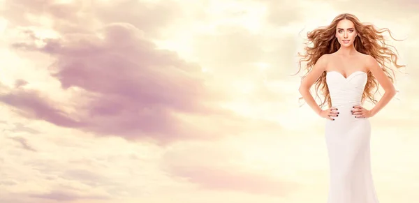 空の夕日の上に白いドレスの赤い髪の花嫁 ロングカーリーヘアスタイルアートポートレートと美容モデル ファンタジーレッドヘッド女性オーバーサニーサンシャイン背景 — ストック写真