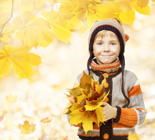 Criança de outono em folhas, criança pequena em chapéu de lã, roupas de malha para a temporada de outubro — Fotografia de Stock