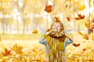 küçük çocuk düşen sarı ile oynarken mutlu gülen çocuk portre sonbahar Park, yaprakları