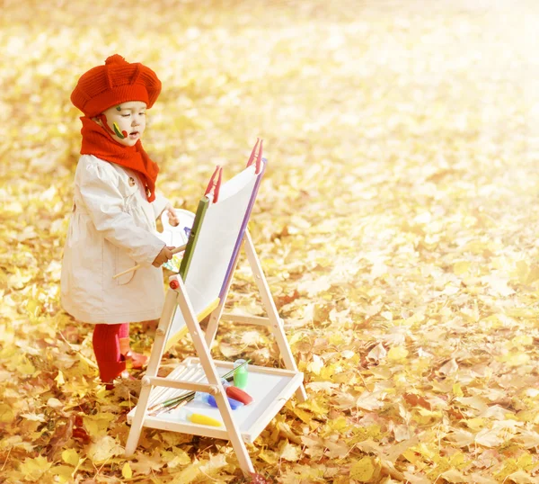 Kind in herfst park schilderij foto op ezel. creatieve kleine jongen en geel vallen bladeren. voorschoolse educatie en vroege ontwikkelingsconcept — Stockfoto