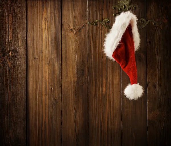 Natal Papai Noel chapéu pendurado na parede de madeira, conceito de Natal, decoração sobre Grunge fundo de madeira — Fotografia de Stock