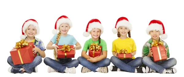 Kerstmis kinderen, huidige doos van de Gift, Santa Red Hat, kinderen jongens en meisjes gelukkig groet kerstvakantie Rechtenvrije Stockafbeeldingen