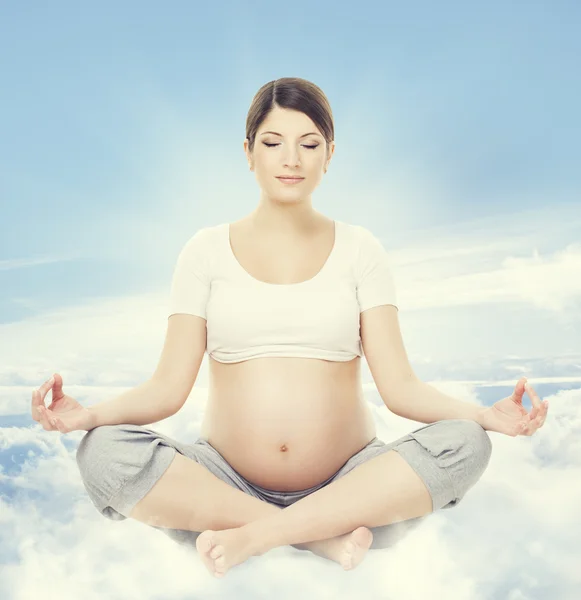 Pregnant Woman Yoga Meditation. Pregnancy Health Wellness and Relax Exercising. Mother Sitting in Lotus Position Crossed Legs over Sky Background — Stock Photo, Image
