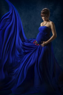 Hamile kadın Güzellik Portresi, güzel annelik kavramı, anne moda mavi elbise, uçan ve sallayarak bez çırpınan