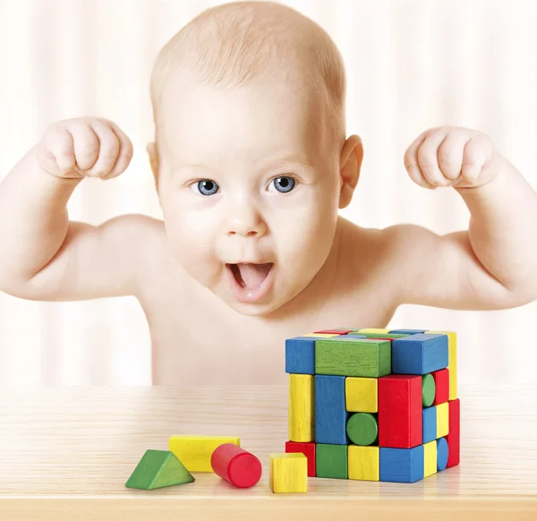 Bebé inteligente jugando bloques de juguete, niño sano fuerte que ríe, levantamiento de la mano, desarrollo temprano del éxito de los niños pequeños y concepto de la actividad, juego del rompecabezas — Foto de Stock