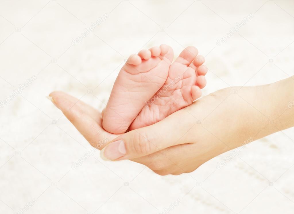 Baby Newborn Feet in Mother Hands. New Born Kid Foot, Family Love