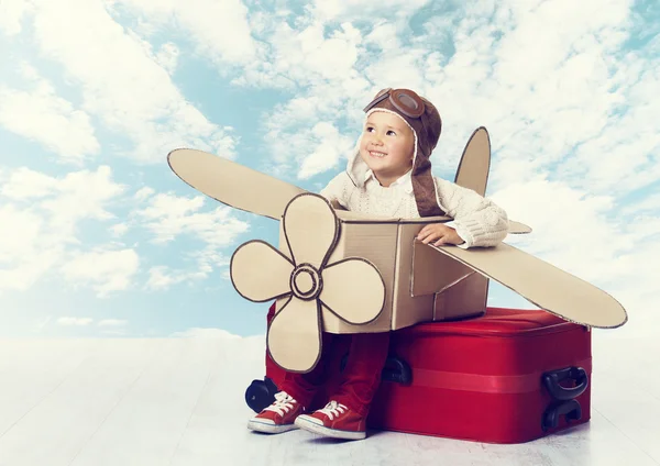 Niño jugando piloto de avión, niño viajero volando en casco en la maleta — Foto de Stock