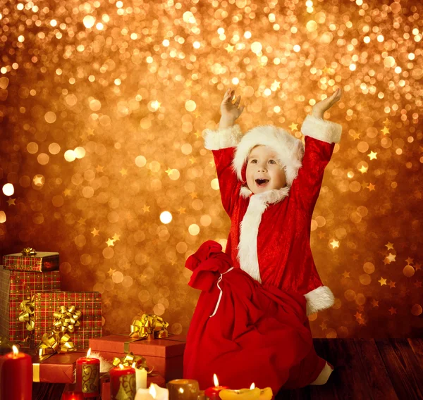 Weihnachtskind, glückliches Kind Geschenke und rote Weihnachtsmanntasche, Junge — Stockfoto