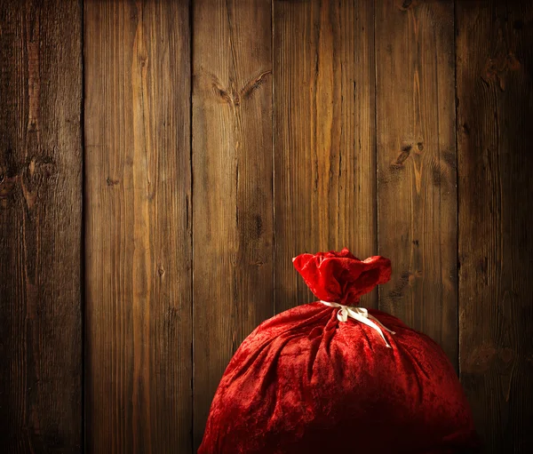 Sacchetto rosso di Natale pieno, Sfondo della parete di legno di Natale, Struttura in legno plance — Foto Stock
