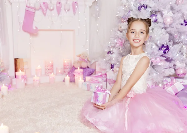 Vánoční dívka dítě. Kid zdobené růžové současné dárek — Stock fotografie