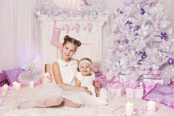 Рождественские дети, малыши и девочки, украшенная рождественская розовая комната — стоковое фото